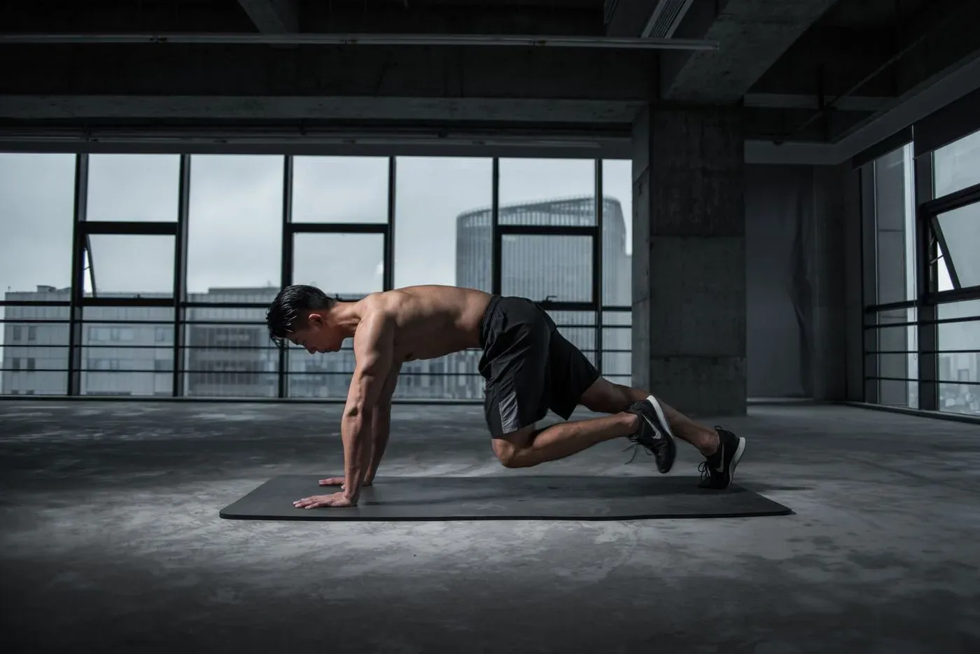 Pratiquant réalisant un mouvement d'échauffement dynamique en gainage sur un tapis